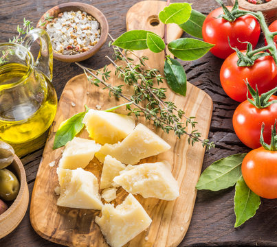 Parmesan cheese on wooden cutting board. Food background.