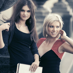 Two young fashion female students at university campus