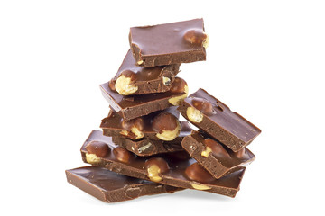 Heap of broken chocolate with nuts on a white background
