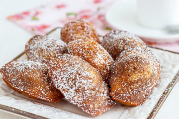French cookies Madeleine and tea in white cup. Concept romantic Breakfast. Selective focus.