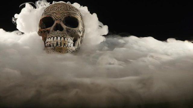Skull covered in smoke on a dark background