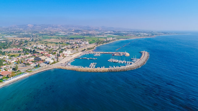 Aerial Bird's Eye View Of Zygi Fishing Village Port, Larnaca, Cyprus. The Fish Boats Moored In The Harbour With Docked Yachts And Skyline Of The Town Near Limassol City From Above.