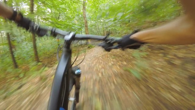 Downhill mountain biking first person point of view on bike trail in summer woods. Forest extreme speed riding, first person perspective view POV. Gimbal stabilized video GOPRO HERO4 4K.