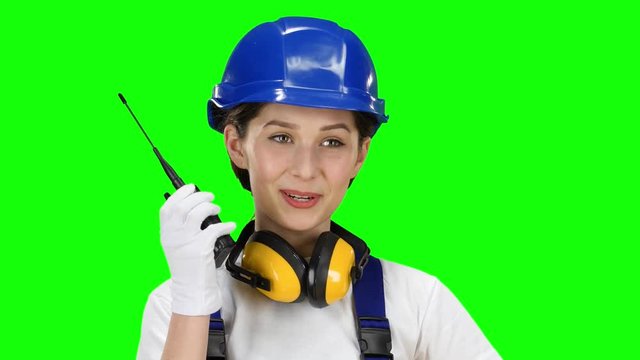 Bilder girl wearing wearing talks on the walkie talkie. Green screen. Close up