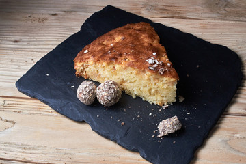Apple pie tart on shale board with raisins, nuts and cinnamon is a vintage wooden background texture. Rustic style