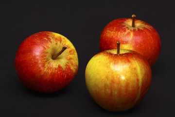 Three red ripe apples isolated on a black background
