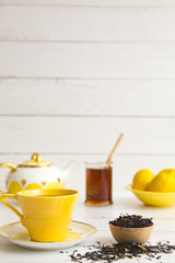 Fototapeta na wymiar Bright Yellow Tea Set on a White Wood Table