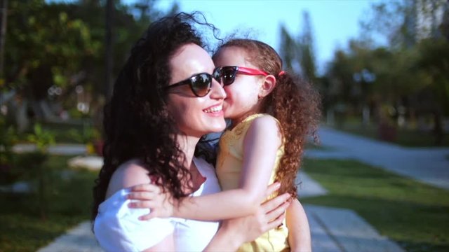 Daughter rushes into the mother's arms on the street and gives her a big hug. Slow motion. Stock footage.