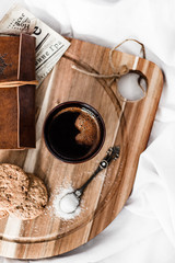 Top view photo of a coffe, cookies, spoon of sugar and vintage notebook on a wooden board