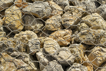 Big stones under metal wire fence background