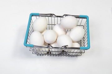 the Shopping Basket With blue Handle and white eggs