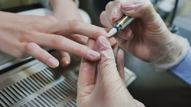 Removing old cover. Woman's hands at manicure procedures