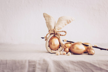 Still Life Happy Easter Background. Gold eggs and linen napkin with decorations