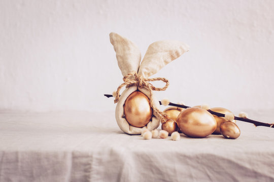 Still Life Happy Easter Background. Gold eggs and linen napkin with decorations