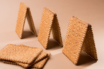 several bungalows or small houses made of biscuits on a brown background