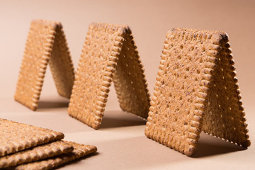 several bungalows or small houses made of biscuits on a brown background
