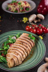 Chicken steak roasted and salad, food photography. Black background. Top view