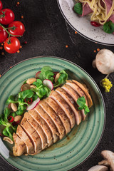 Chicken steak roasted and salad, food photography. Black background. Top view