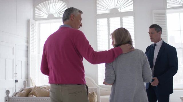 Mature couple viewing a property with a real estate agent