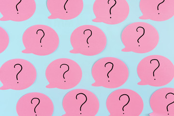 Sticky notes on a blue background. Pink stickers with question marks. A vivid unusual photo.