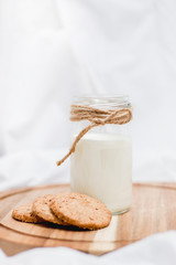 Photo of a milk and cookies on a wooden board