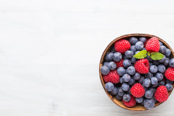 Juicy and fresh blueberries with green mint on rustic blue table.