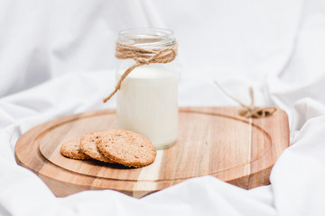 Photo of a milk and homemade cookies on a wooden board