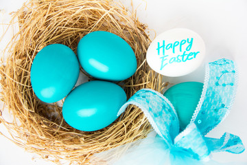 Multi-colored Easter eggs in nest on wooden background, selective focus image. Happy Easter card 
