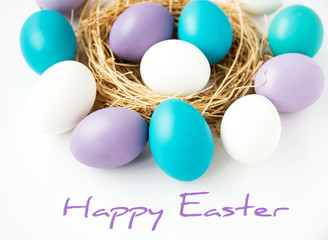 Multi-colored Easter eggs in nest on wooden background, selective focus image. Happy Easter card 