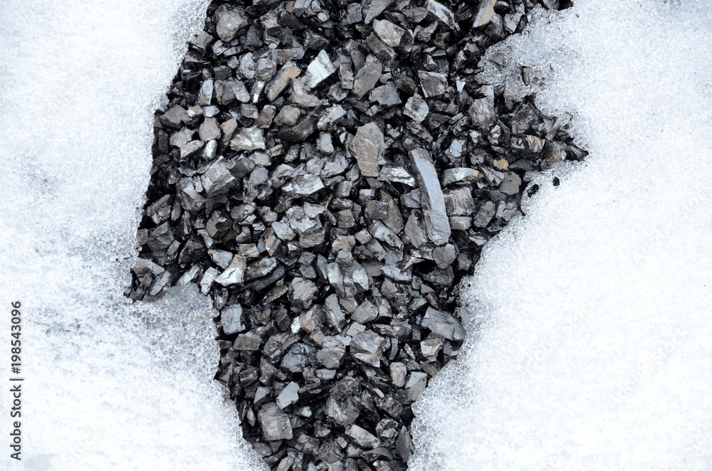 Poster the background consisting of two parts of snow and a part of coal anthracite in the form of thawed p