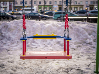 close up swings in the city street on a winter snowy day