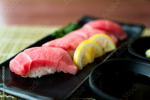Otoro Tuna Sushi On Black Plate Along With Anese Sauce And Green Otoro Tuna Sushi On Black Plate Along With Anese Sauce And Green Leaf Decoration