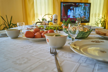 Easter table with food and decorations, eggs, salad, plates