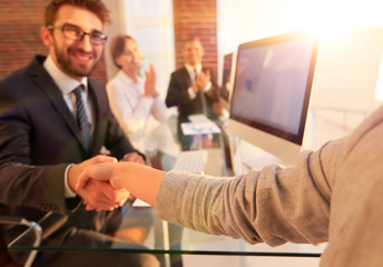 Fototapeta premium businessman shaking hands with a business partner sitting near your desktop