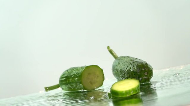 Cucumber and slices splashing, slow motion