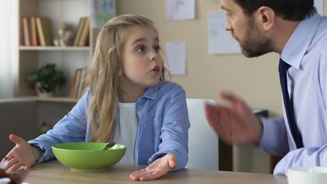 Strict father shouting at daughter, forcing to eat, demanding man scolding child