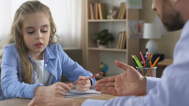 School girl arguing with father while doing homework, puberty age, conflict