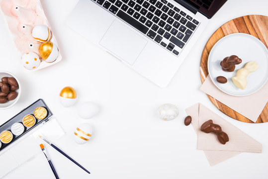 Happy Easter! Stylish stationery background with chocolate eggs. gold and white eggs and accessories on white background. Table decorating for holiday. Feminine flat lay. Office easter concept.