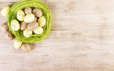 Fototapeta na wymiar Easter Eggs Easter Nest Background Yellow Green Brown Pastel Colors. Text space, top view.