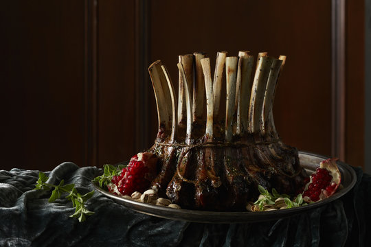 Rack of lamb with pomegranate on a plate with herbs and pistachios