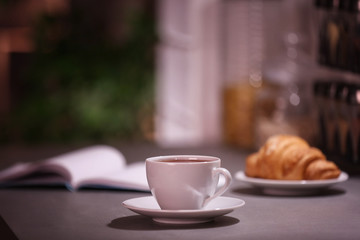 Cup of hot coffee on blurred background