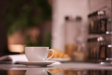 Cup of hot coffee on blurred background
