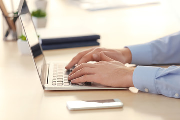 Young man with laptop working in office