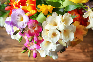 Beautiful bouquet of freesia flowers on table, closeup