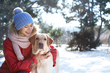 Woman with cute dog outdoors on winter day. Friendship between pet and owner