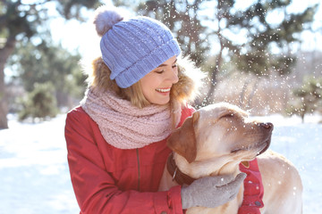 Portrait of woman with cute dog outdoors on winter day. Friendship between pet and owner