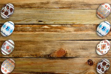 Happy Easter card. Colorful shiny easter eggs on wooden table background. Copy space for text.