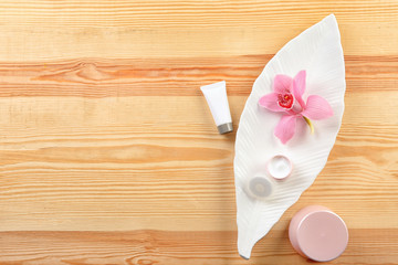 Flat lay composition with body care cosmetics on wooden background