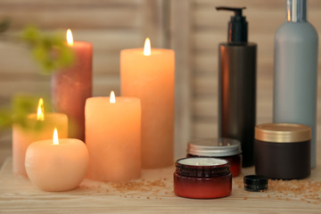 Fototapeta na wymiar Body care cosmetics and burning candles on table