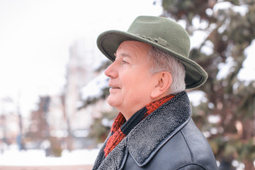 Senior man in warm clothes outdoors. Winter vacation